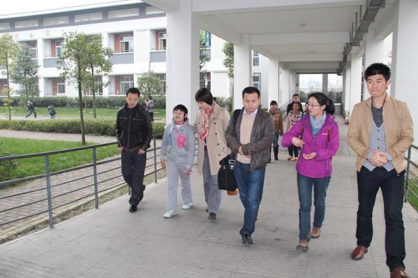 友爱学校周丽校长(右二)、副校长杨伟松(左一)、德育办主任车进(右一)及残疾学生代表陪同来宾参观校园